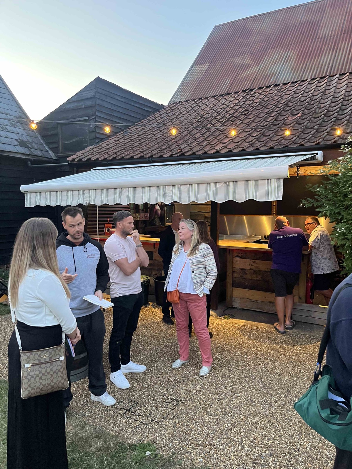 Guests networking at the outdoor bar at dusk
