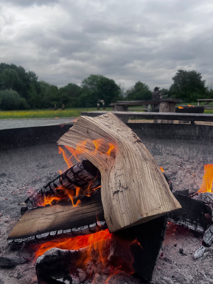 Logs aflame in the fire pit under an open Suffolk sky