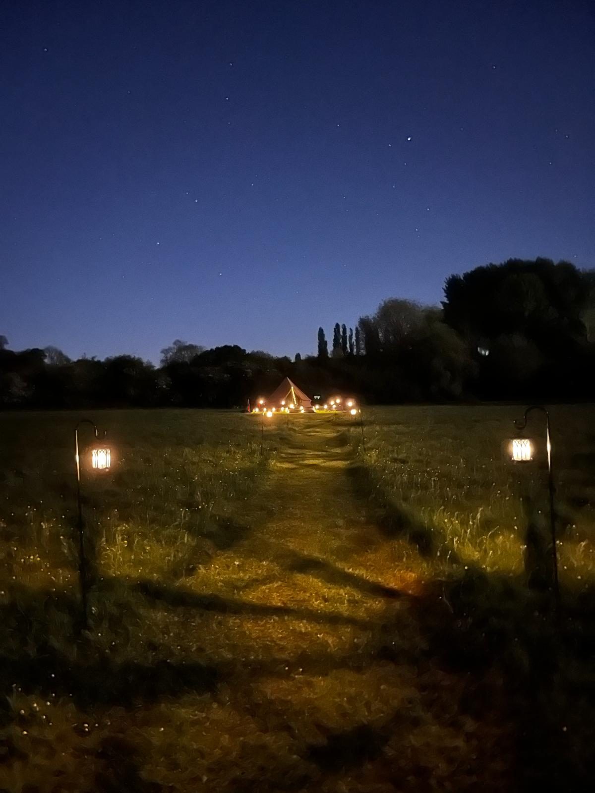 The Barn at Flint Hall under string lights at night