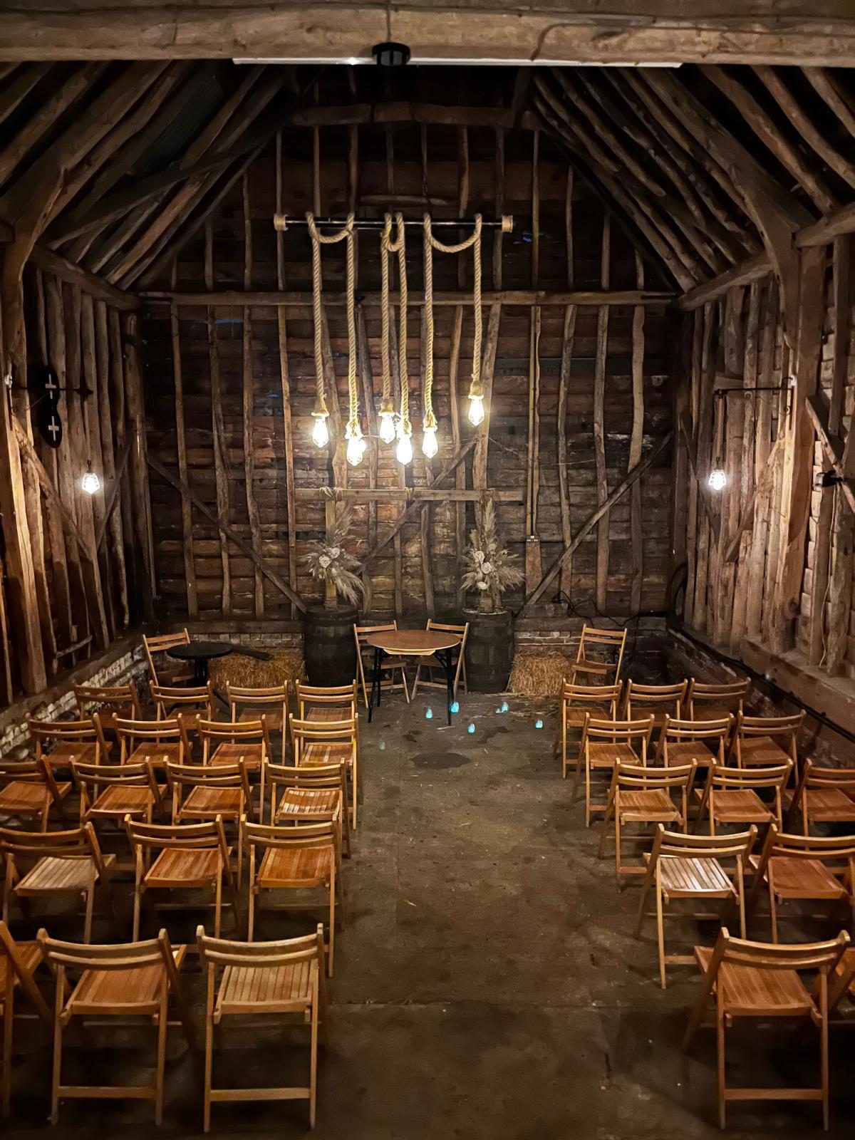 Inside the Barn — ceremony setup with rope-Edison bulbs and dried flowers
